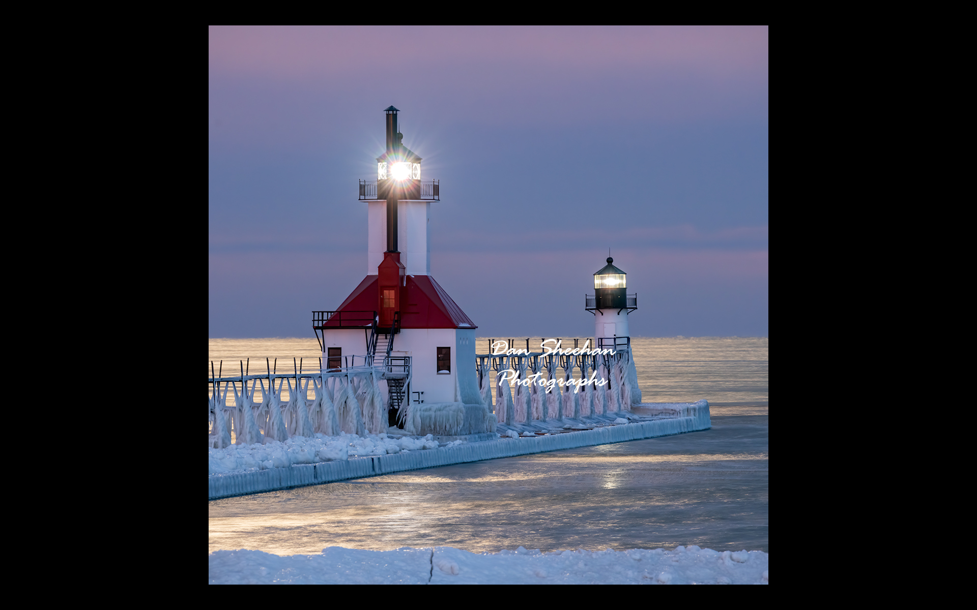 St. Joseph, Michigan lighthouse photographed before dawn with both beacons burning brightly under a setting full moon. The full effect of the moonlight can be seen towards the horizon where all of Lake Michigan is lit.  : Lighthouses : Dan Sheehan Photographs - Fine Art Stock Photography