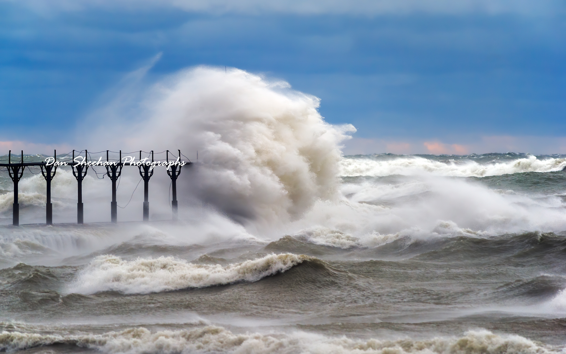 There are bad days and then there are very bad days. Shown here is the St. Joseph, Michigan outer lighthouse enduring a very bad day. The destructive force of this storm has left the cables along the catwalk in  shambles. Storms over decades and decades have done their best to destroy this lighthouse but this guiding light remains undefeated. : Lighthouses : Dan Sheehan Photographs - Fine Art Stock Photography